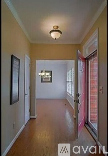 A hallway with a light on the ceiling and a framed picture on the wall.