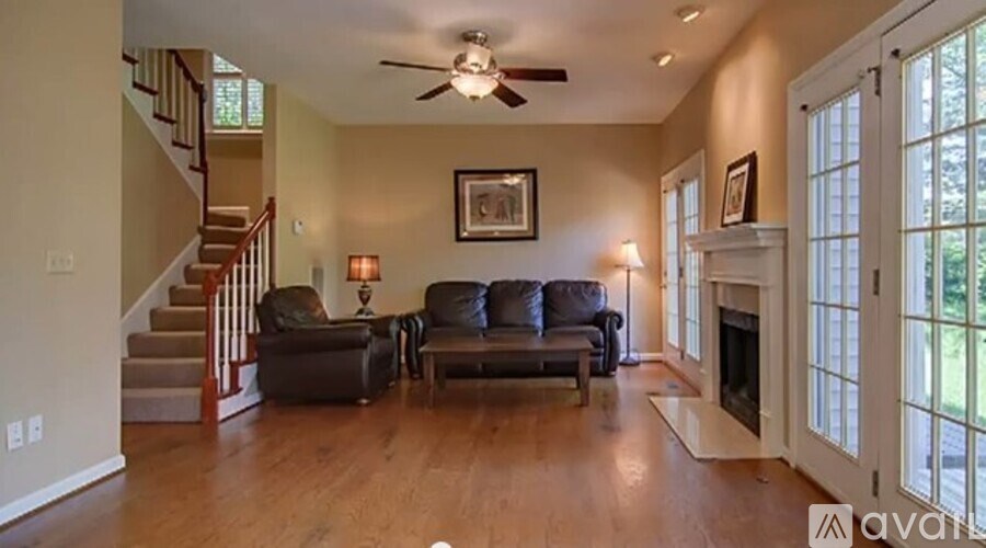 A living room with a staircase and a fireplace.