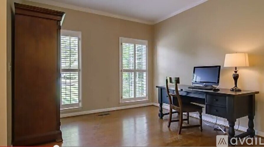 A room with a desk and chair in it.