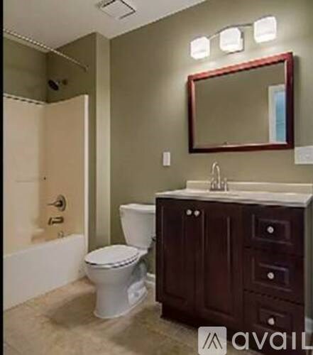 A bathroom with a toilet, sink, and mirror.