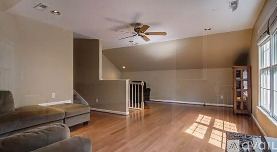 A living room with a ceiling fan and a couch.