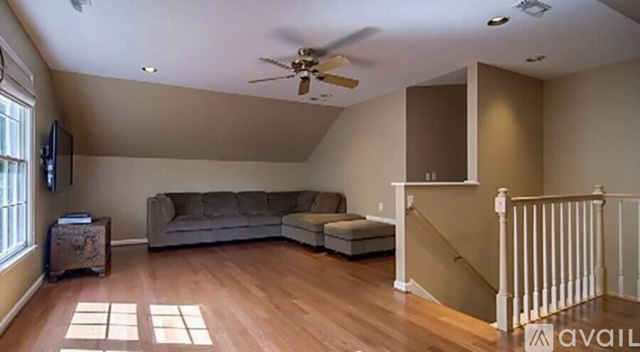 A living room with a grey couch and a wooden floor.