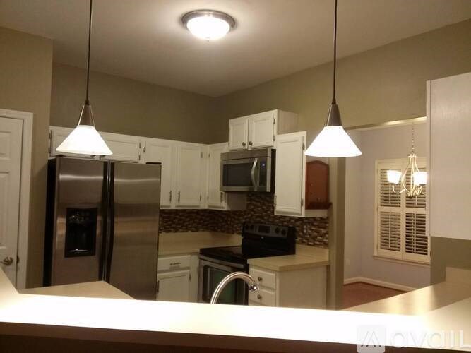 A kitchen with a refrigerator, microwave, and oven.