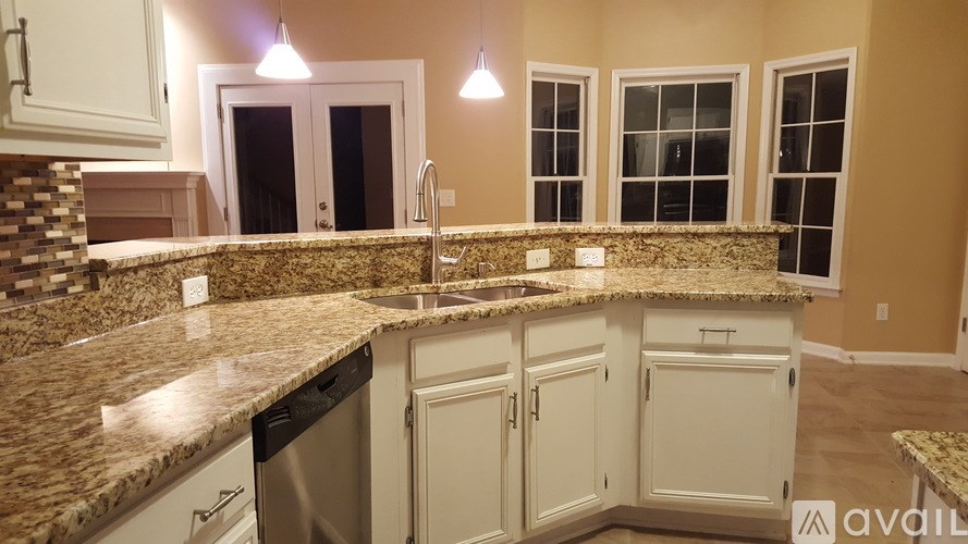 A kitchen with granite countertops and white cabinets.