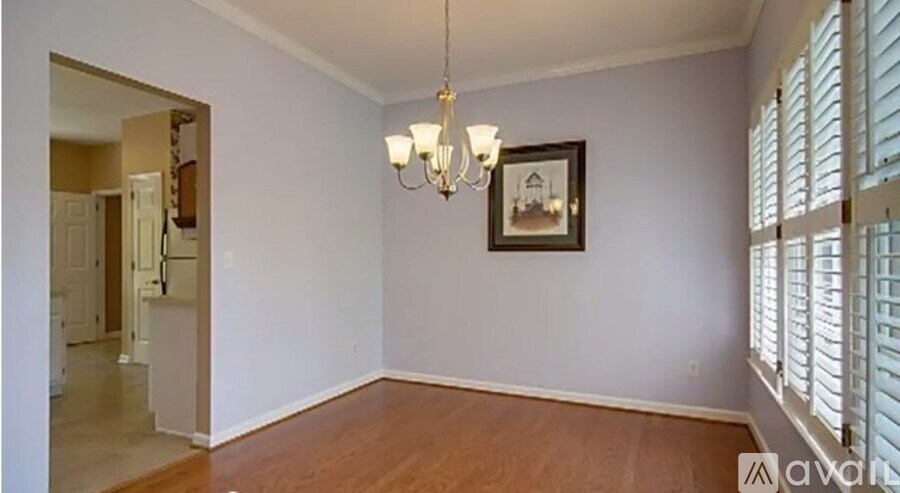 A room with a chandelier and a picture on the wall.