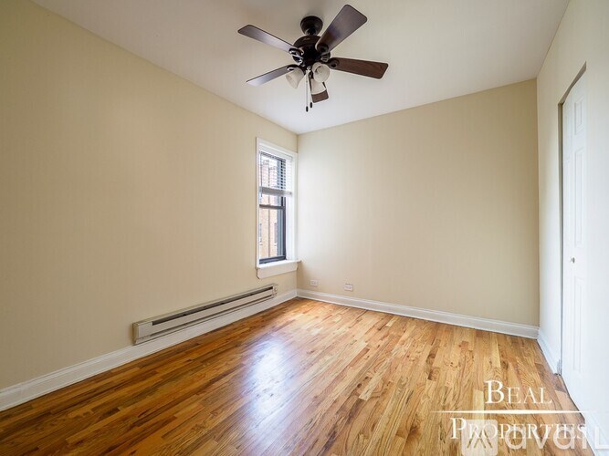 A room with a ceiling fan and wooden flooring.