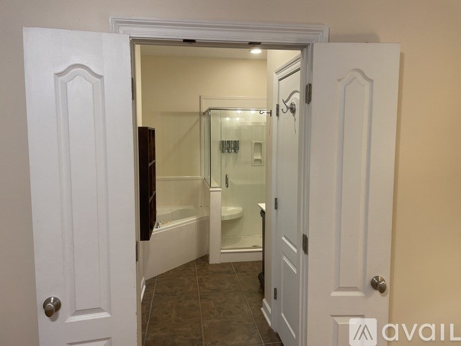 A bathroom with a glass shower door and a bathtub.