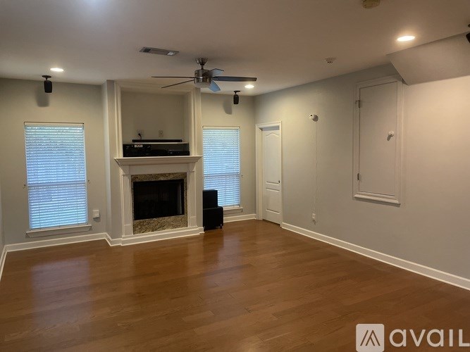 A living room with a fireplace and a ceiling fan.