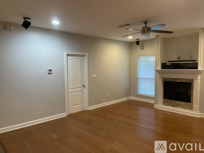 A room with a fireplace and a ceiling fan.