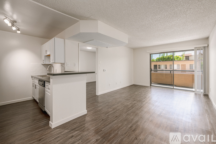 A kitchen with white cabinets and a black countertop is available for rent.