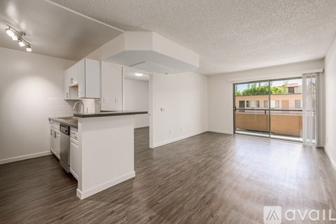 A kitchen with white cabinets and a black countertop is available for rent.