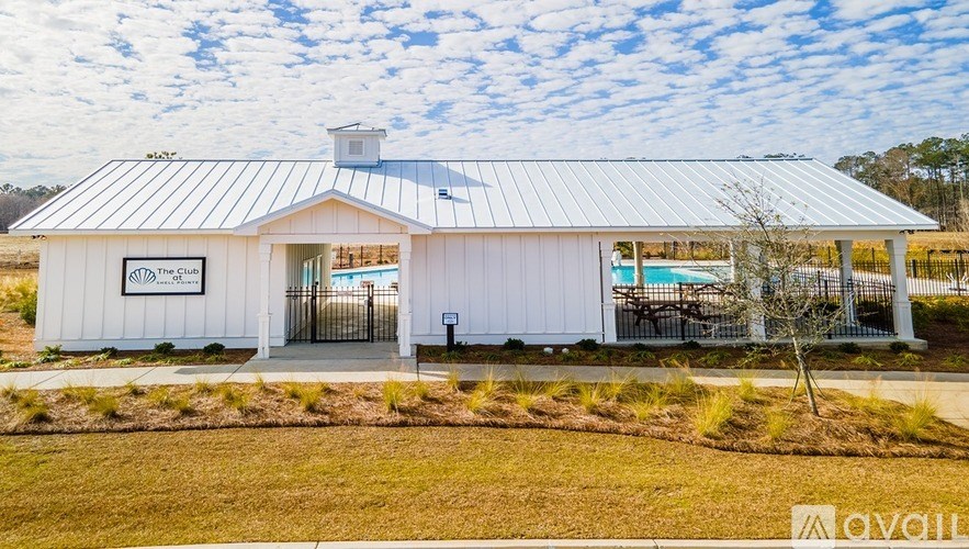 A white building with a sign that says "The Club" on it.