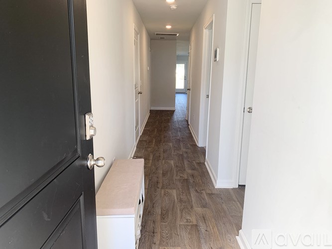 A long hallway with a bench and doors on either side.