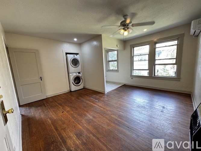 A room with a ceiling fan and a washing machine in it.