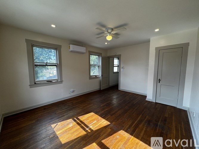 A room with wooden floors and a ceiling fan.