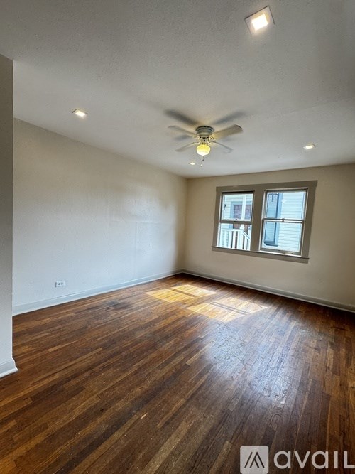 A room with wooden flooring and a ceiling fan.