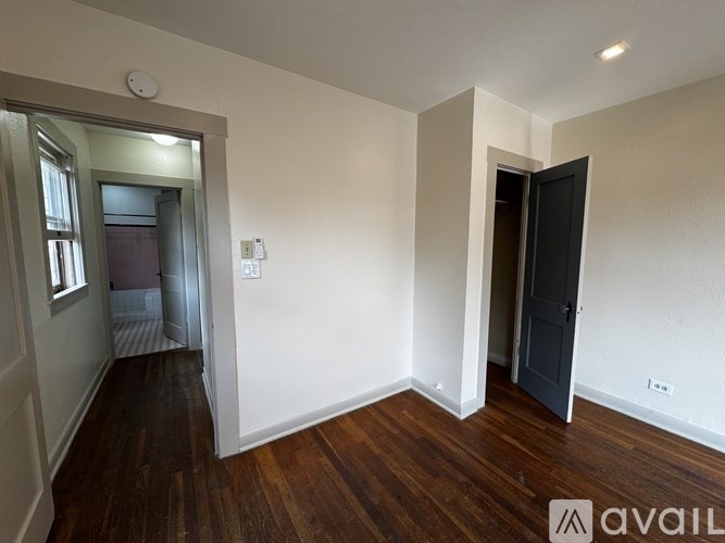 A room with a wooden floor and a door on the right side.