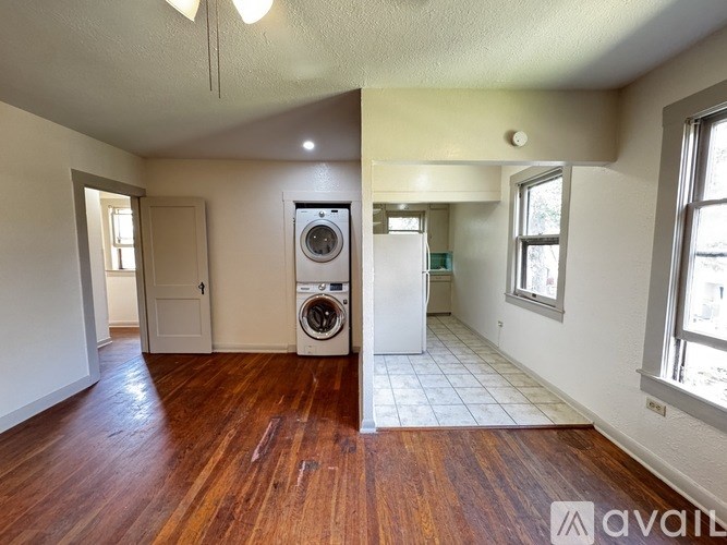 A room with wooden floors and a washing machine.