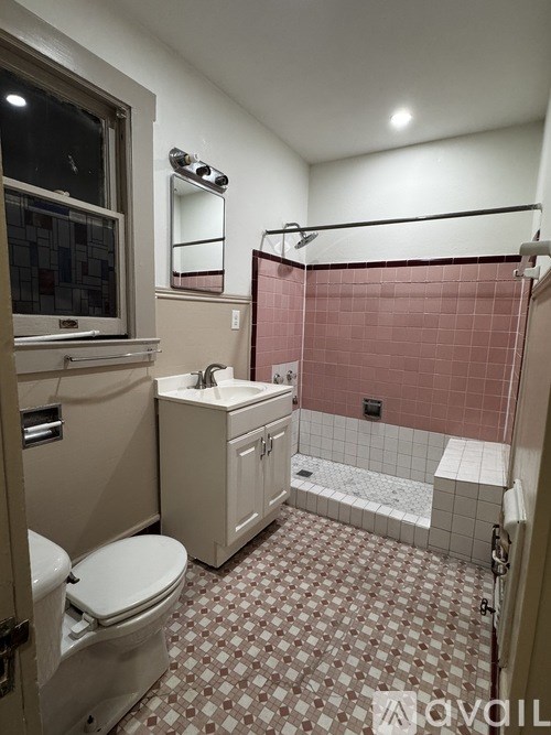 A bathroom with a toilet, sink, and shower.