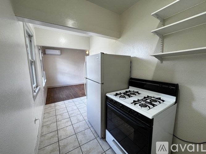 A kitchen with a white stove and a white fridge.