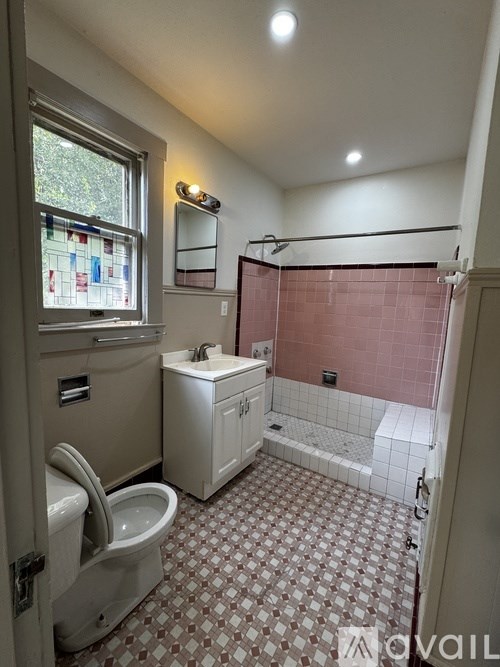 A bathroom with a toilet, sink, and shower.