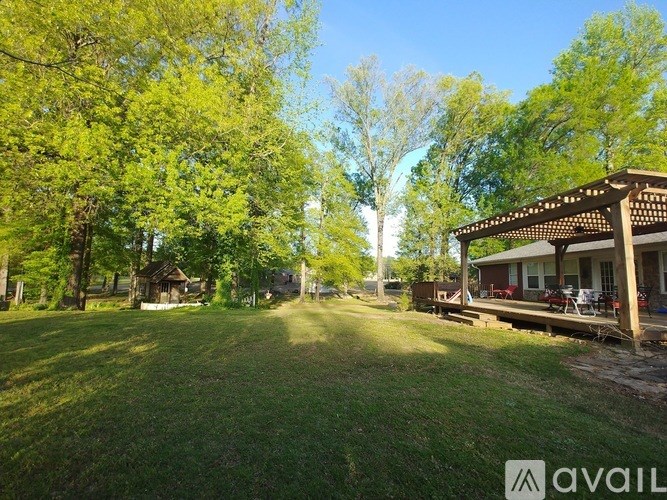 A sunny day at a park with a gazebo and trees.
