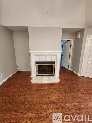 A living room with a fireplace and wood flooring.