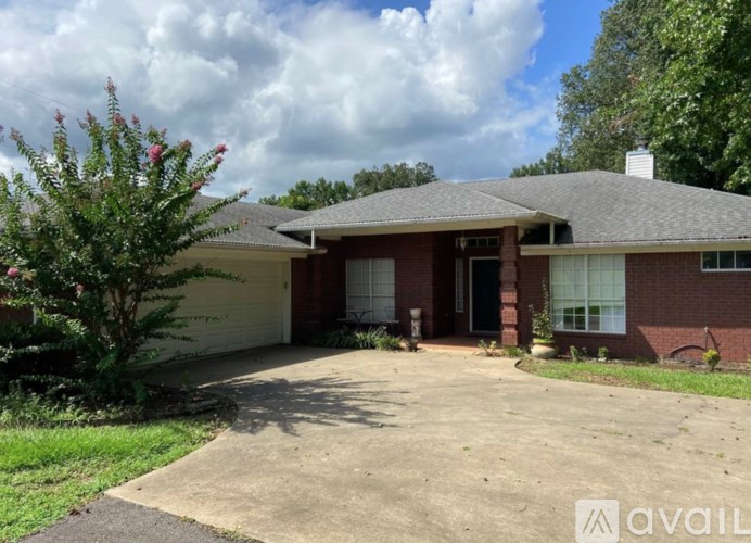 A house with a driveway and a tree in front.