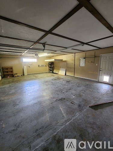 A large empty room with a concrete floor and a ceiling with exposed beams.