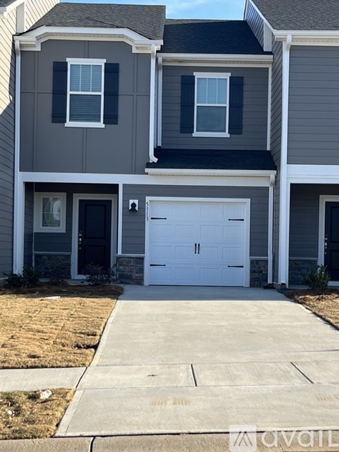 A two-story house with a white garage door.