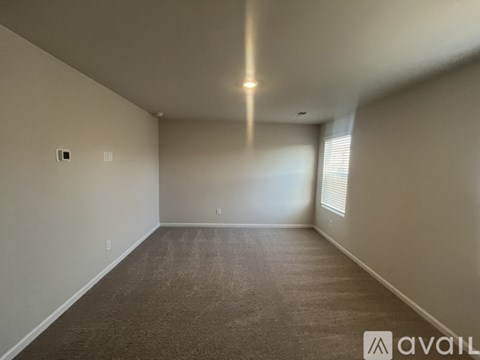 A spacious room with carpeted floor and white walls.