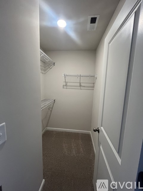 A small, empty room with a door and a shelf.