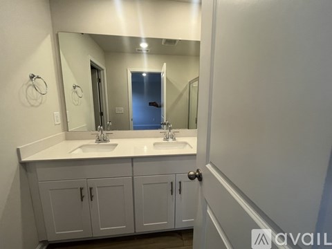 A bathroom with a double sink vanity and a large mirror.