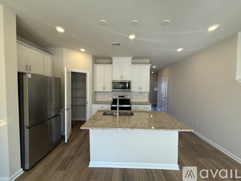 A kitchen with a granite countertop and stainless steel appliances.