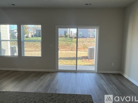 A room with a view of a yard through a sliding glass door.