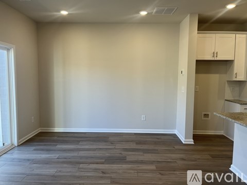 A room with wooden flooring and white walls.