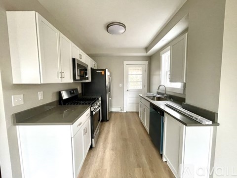 A kitchen with white cabinets and black appliances.