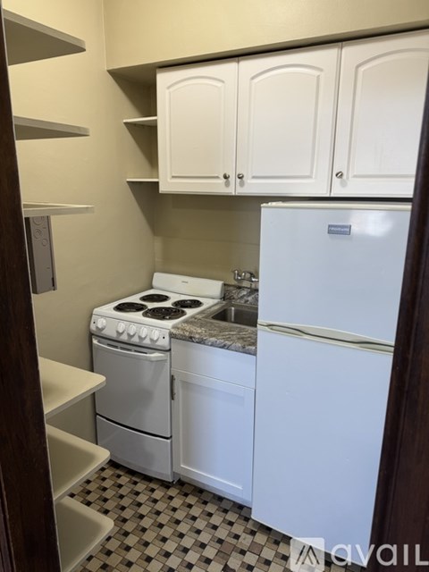 A kitchen with a white fridge, stove and cabinets.