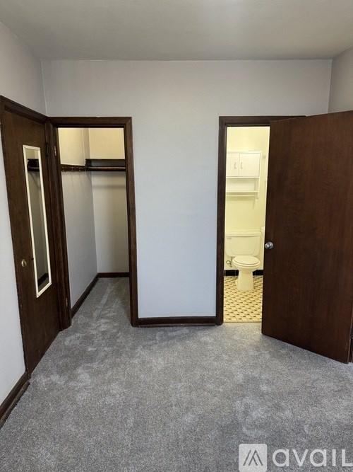 A room with a carpeted floor and two open doors.