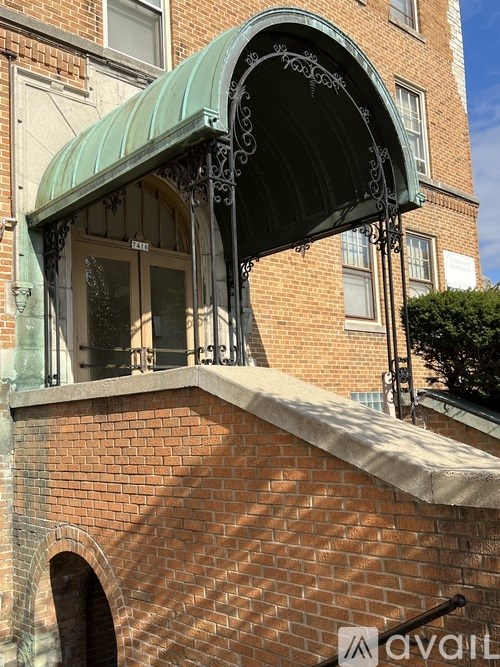 A building with a green awning and a brick wall.
