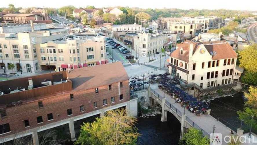 A bridge over a river with cars on it and buildings around.