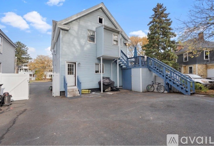 A house with a blue staircase and a bicycle parked in front.