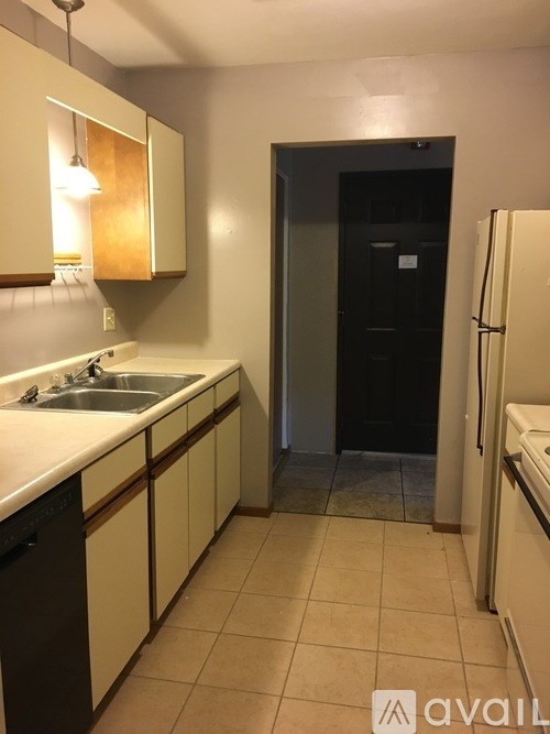 A kitchen with white cabinets and a black fridge.