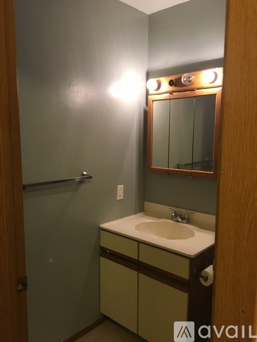 A bathroom with a sink, mirror, and lights.
