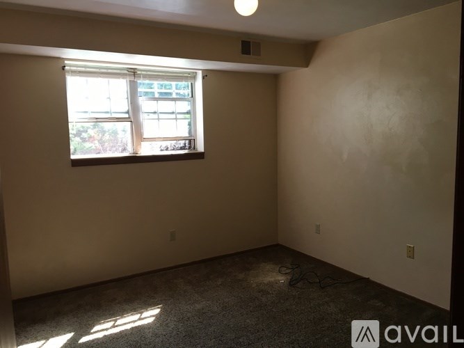 A room with a window and a carpeted floor.