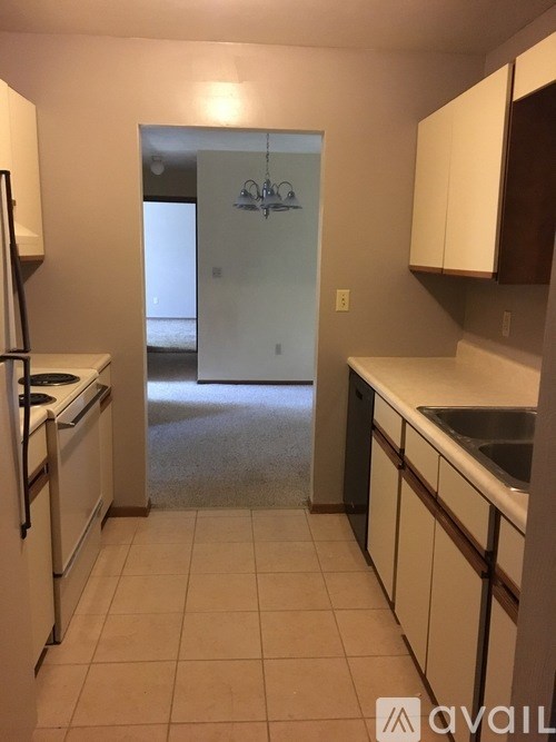 A kitchen with white appliances and brown cabinets.