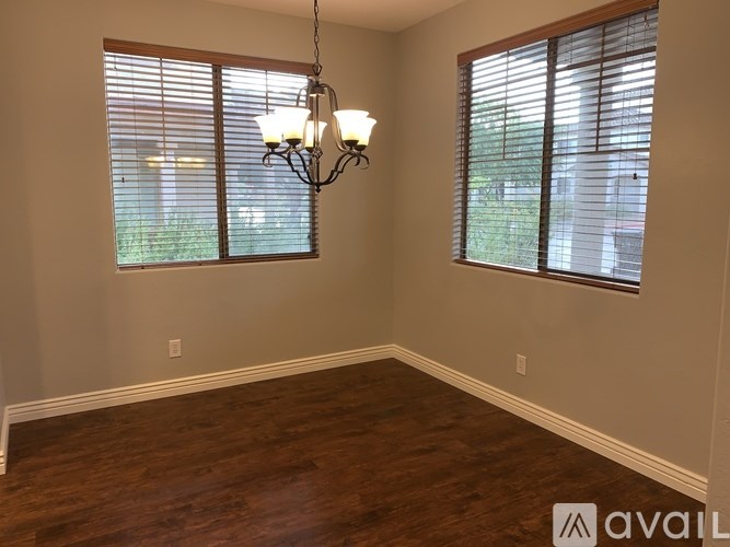 A room with wooden floors and a chandelier hanging from the ceiling.