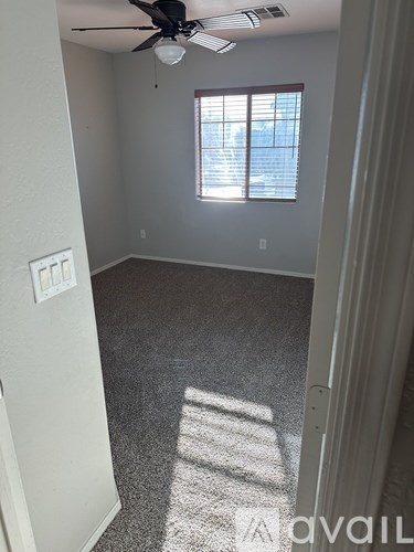 A room with a ceiling fan and a window.