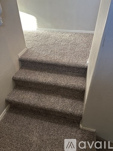 A carpeted staircase with a logo on the bottom right.
