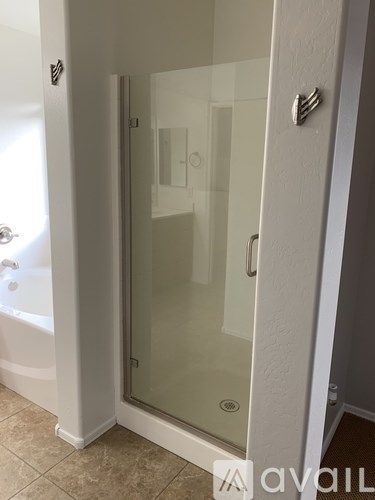 A white bathroom with a glass shower door.
